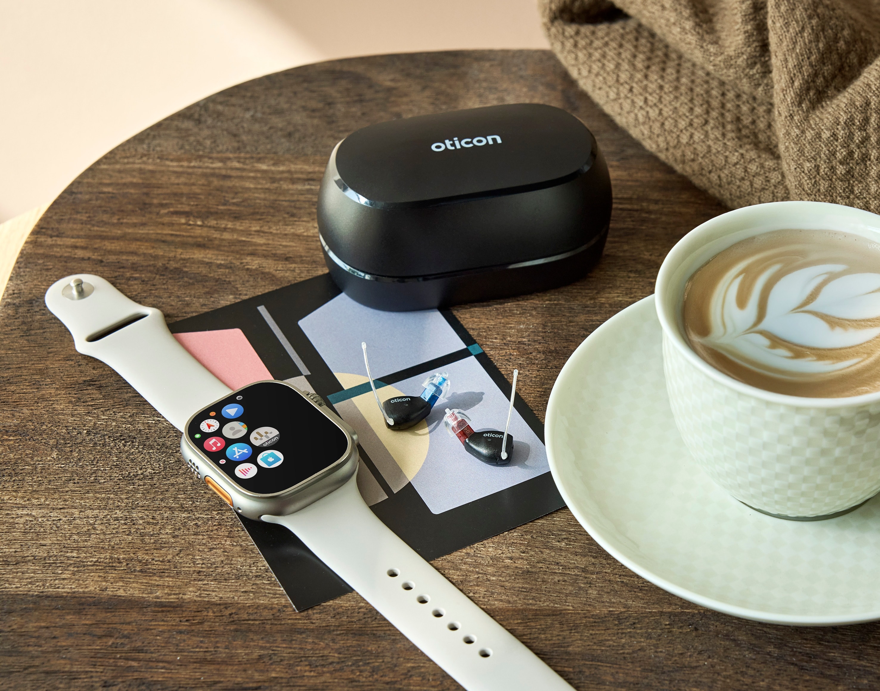 Oticon Zeal hearing aids with Apple Watch and coffee cup lifestyle photo